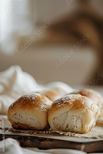 Golden-brown dinner rolls on a wooden board, soft and fresh.