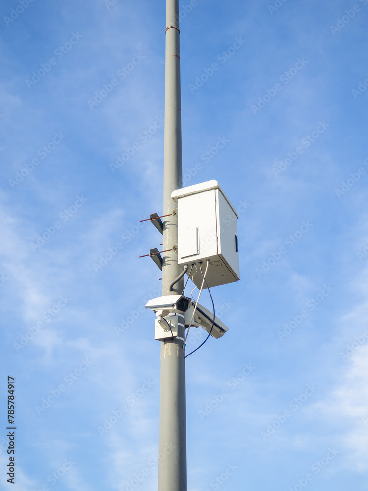 Street surveillance cameras along with a transformer. Pole observation technique. Against the sky. People safety concept. Street surveillance cameras along with a transformer. Pole observation technique. Against the sky. People safety concept.
