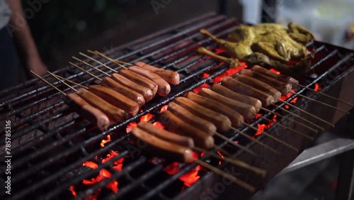 Grilled sausages are being grilled on a grill using areng photo