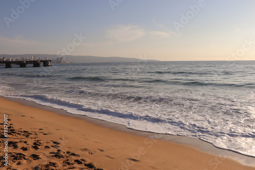 Mar aberto com areia clara e espuma photo