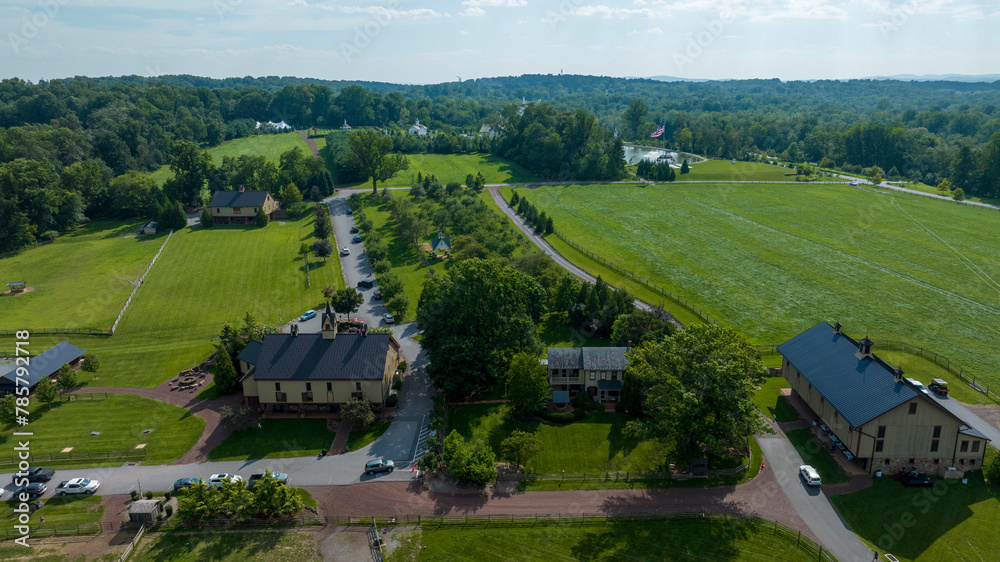 Aerial View Of A Lush Green Estate With Neatly Trimmed Lawns, A Winding Road, Fenced Paddocks
