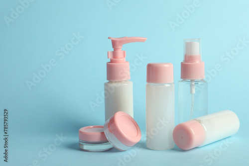 Cosmetic travel kit on light blue background. Bath accessories. Space for text