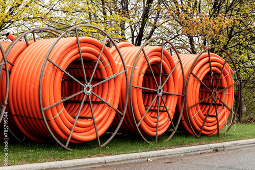 Spools of orange fiber optic cable underground conduit on a mobile reel for fiber optic cable installation