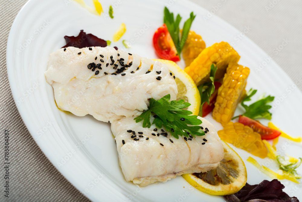 Recipe for delicious steamed hake with fresh tomatoes, herbs, boiled corn and lemon - 250g of fish steam in pan with water and olive oil for 10 minutes, add spices to taste, garnish with vegetables