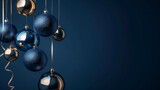 Christmas and New Year minimalistic background. Golden and blue Glass Balls hanging on ribbon on Navy blue background with copy space for text. The concept of Christmas and New Year holidays