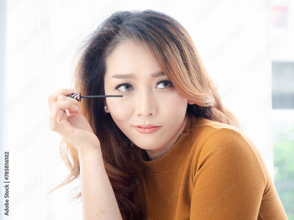 Applying mascara on lushes Asian woman getting makeup with the brush. Woman eye with beautiful makeup and long eyelashes. Applying mascara on lushes Asian woman getting makeup with the brush. Woman eye with beautiful makeup and long eyelashes.