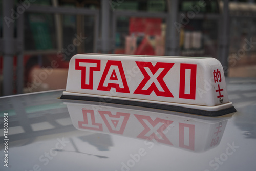 Illuminated Taxi Sign on Car Roof in Urban Setting in Hong Kong photo