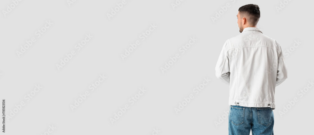 Stylish young man in denim jacket on white background, back view Stylish young man in denim jacket on white background, back view