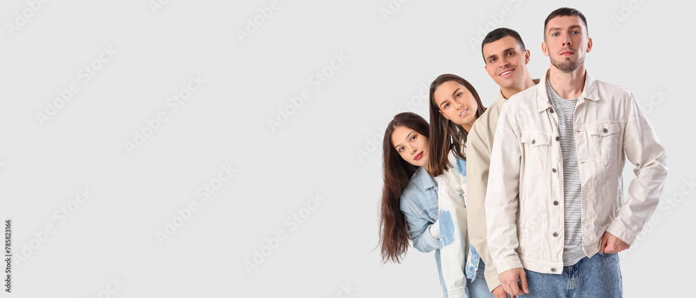 Group of young people in stylish denim jackets on white background