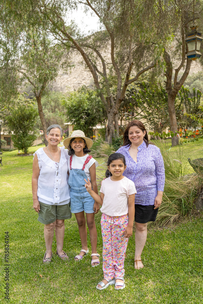 Fototapeta premium A family of four posing for a picture in a park