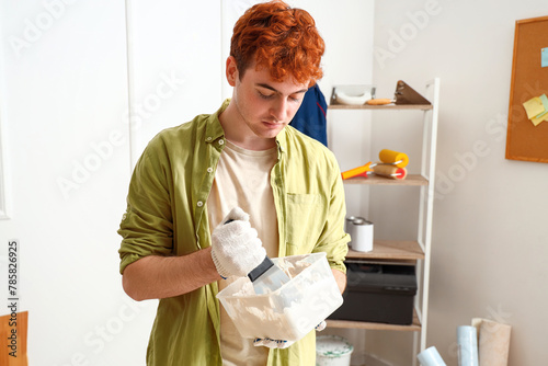Young man with putty knife ...