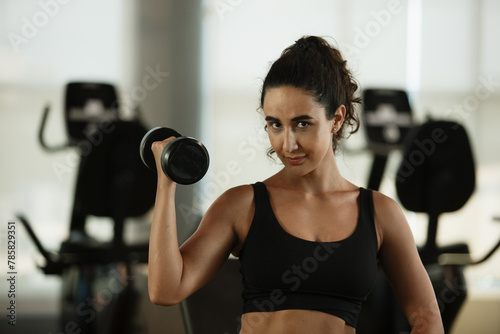 Healthy strong latina female holding dumbbells lifts weights exercise in gym. sport training weights fitness, Exercise to lose weight, take care of health.