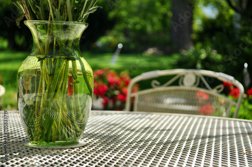 A glass vase on a table in the garden