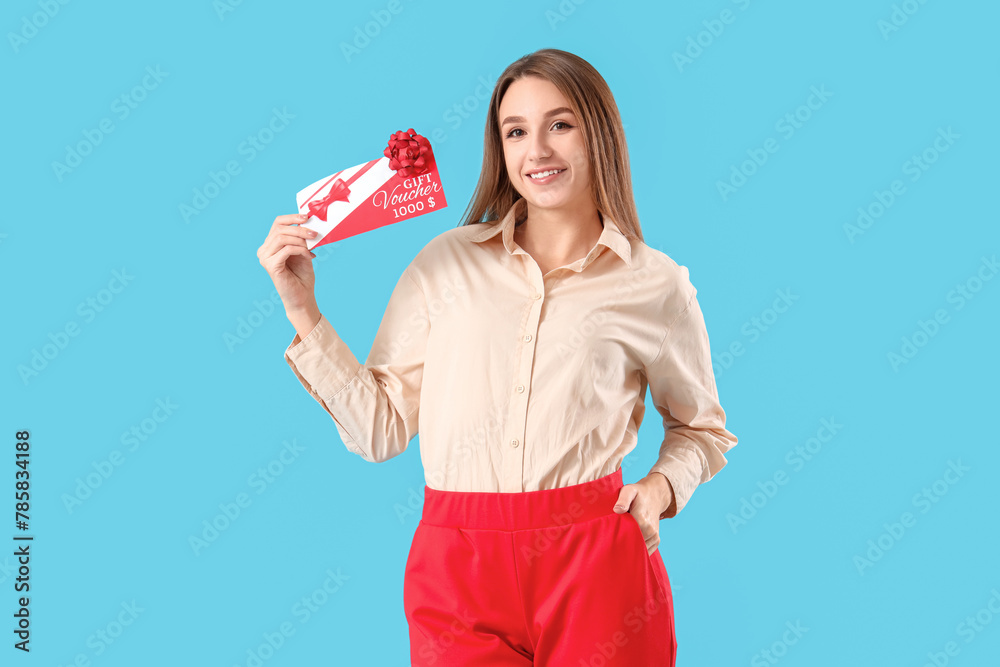 Young woman with gift voucher on blue background Young woman with gift voucher on blue background