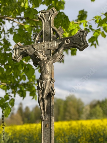 Jesus on the cross by the road next to the field