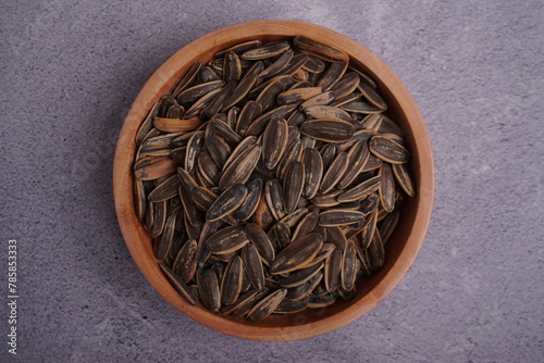 top view of wooden bowl filled with pile of sunflower seed
