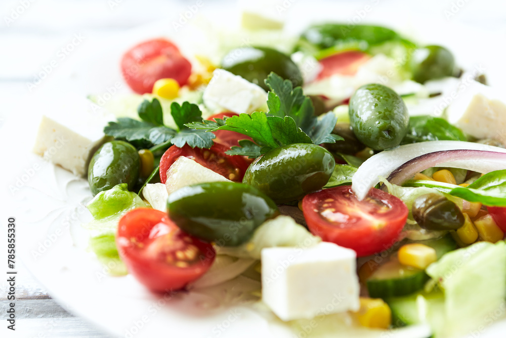 Healthy Salad with Feta Cheese, Green Olives, Baby Spinach, Cucumber, Cherry Tomatoes and Capers. Bright background. Close up. Healthy Salad with Feta Cheese, Green Olives, Baby Spinach, Cucumber, Cherry Tomatoes and Capers. Bright background. Close up.