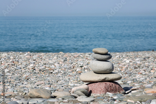 A pyramid of stones on a pebble beach. Close-up. Copy space