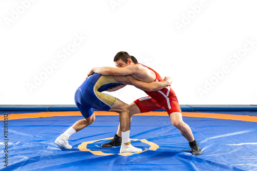 Two  strong men in blue and red wrestling tights are wrestling  on a white background. Wrestlers doing grapple.