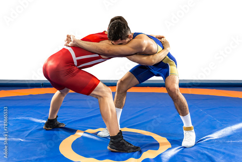 Two strong men in blue and red wrestling tights are wrestling on a white background. Wrestlers doing grapple.