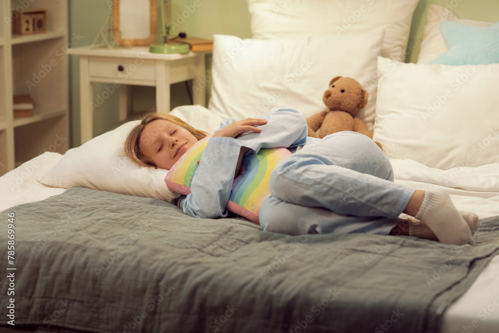 Adorable girl hugging pillow while sleeping on cozy bed Adorable girl hugging pillow while sleeping on cozy bed