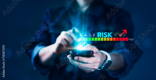 A person is holding a cell phone with a blue screen that says "risk" on it