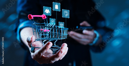 A person is holding a shopping cart with a phone in their hand