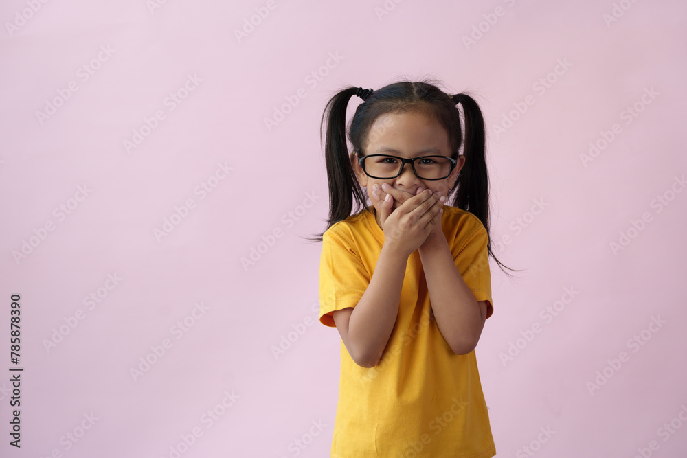 Close-up photo of a cute little girl, cheerful, smart, good at learning, new ideas, and imagination. Expressing various poses based on bright life concept, copy space, and pink pastel background.