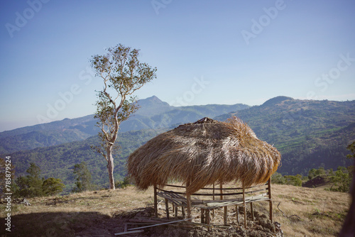 cottage with view of beautiful Hills. Cottage on the hill with bladygrass roof. photo