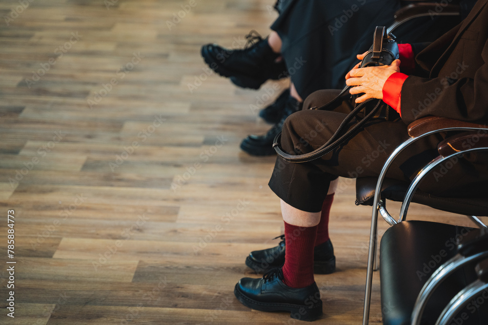 Naklejka premium A group of people rolling on chairs, sitting on a hardwood floor