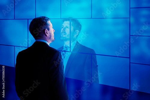 Confident caucasian businessman looking at his reflection in an office
