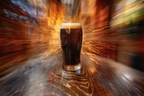 Glass of dark beer on a wooden table in a pub with blurred background