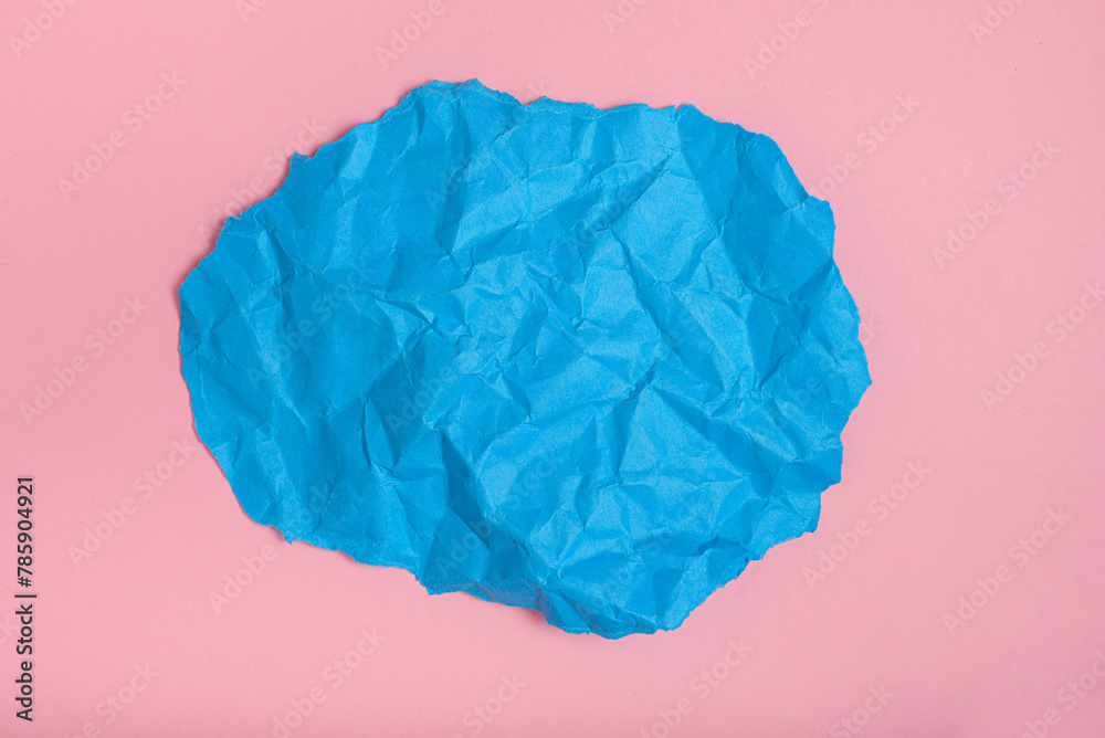 Piece of blue crumpled paper on pink background. Space for text.