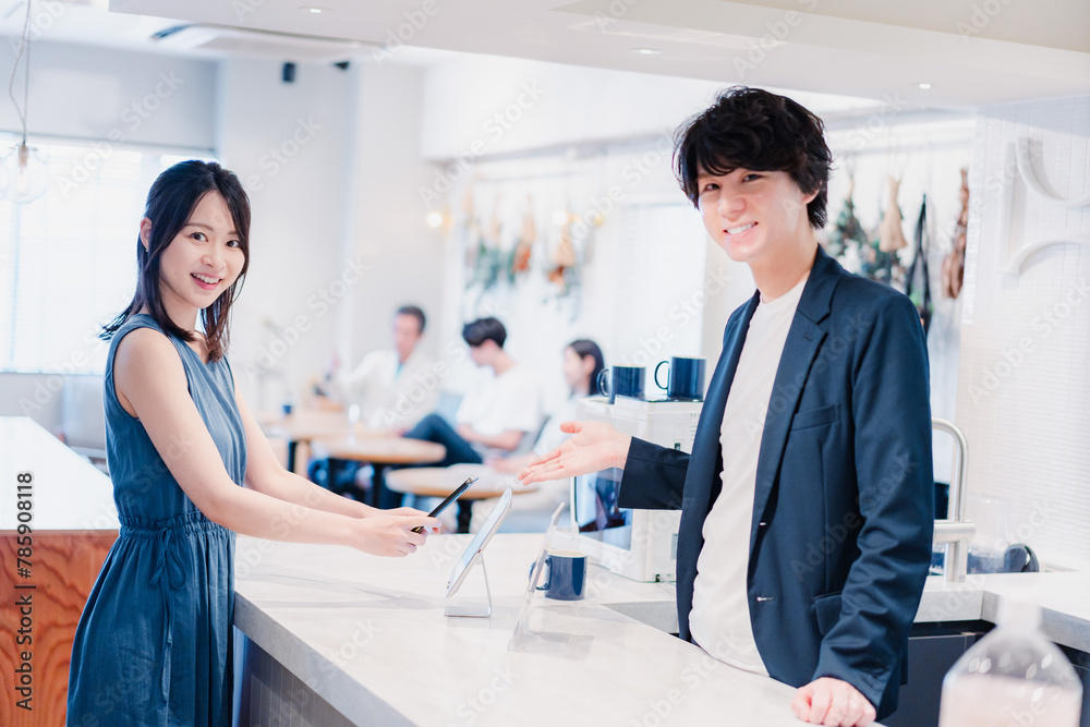 Obraz premium スマホ決済をする若い女性