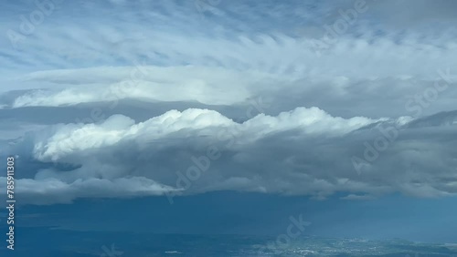 Exclusive shot from a plane cockpit while flying near a huge stormy cumuloninbus cloud. Immersive Pilot POV.  Daylight, blue sky. 4K 60FPS photo