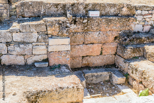 Sunlit ancient stone ruins of water clock at archaeological site in Athens, Greece