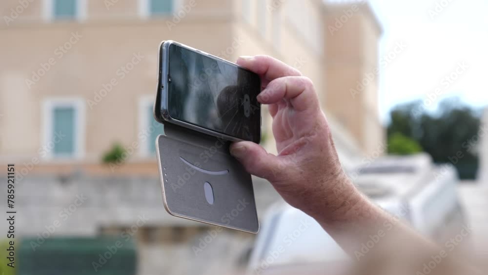 Closeup person holding smartphone shooting video of a parade performance near Royal Palace in Athens Greece
