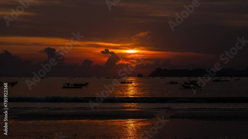 Timelapse Silhouette fishing boat at sunset in Selong Belanak Beach, Lombok, Indonesia photo