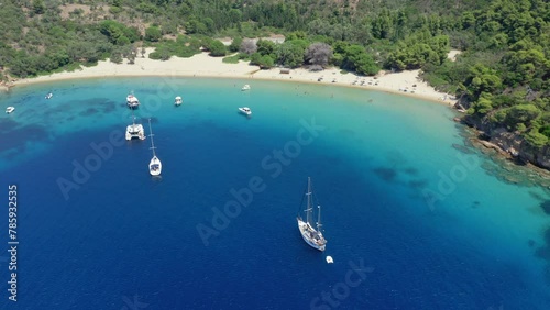 Aerial: Slow orbit drone shot of Tsougria island beach near Skiathos, Sporades, Greece with turquoise and emerald crystal clear water photo