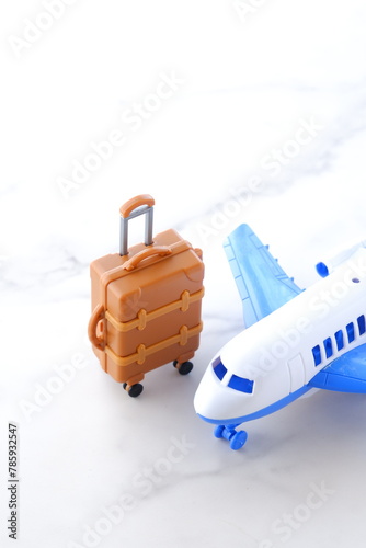 離陸を待つ飛行機とスーツケース（キャリーケース）で、これから旅行に出発するイメージ
