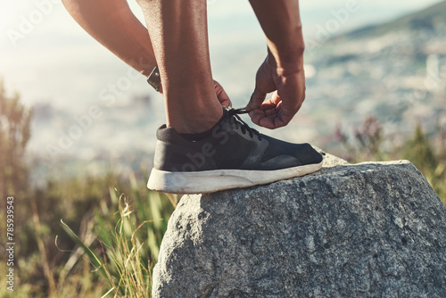Runner, foot and tying laces on rock, outdoors and prepare for cardio and marathon training. Man, stone and shoe for exercise or sports in nature, getting ready and sneaker for workout or athlete
