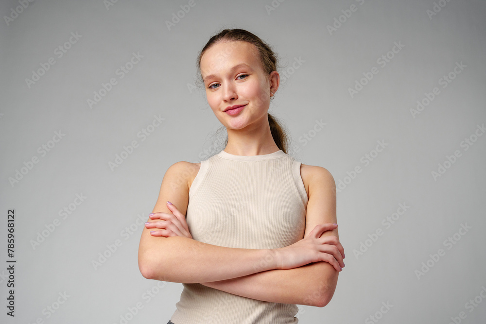 Girl in Beige Tank Top and Grey Jeans on gray background Girl in Beige Tank Top and Grey Jeans on gray background