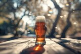 Glass of beer on a wooden table with bokeh background
