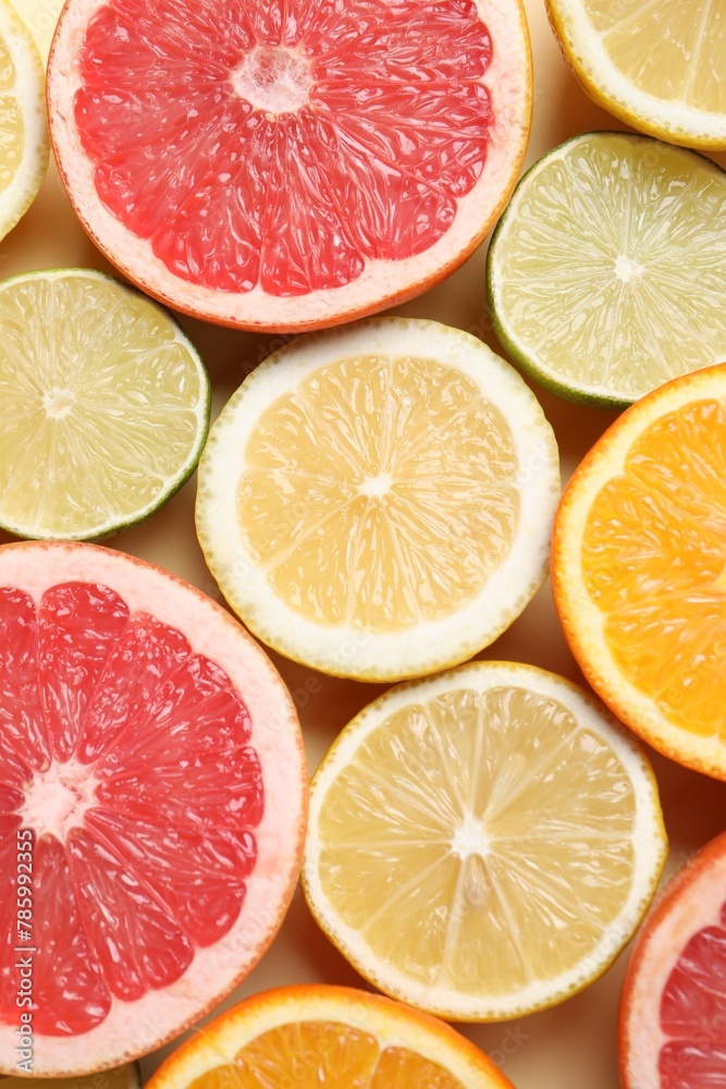 Different cut citrus fruits on beige table, flat lay Different cut citrus fruits on beige table, flat lay