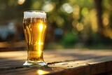 Glass of beer on a wooden table in the garden with bokeh
