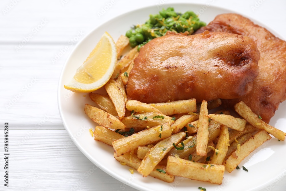 Tasty fish, chips, peas and lemon on white wooden table, closeup Tasty fish, chips, peas and lemon on white wooden table, closeup