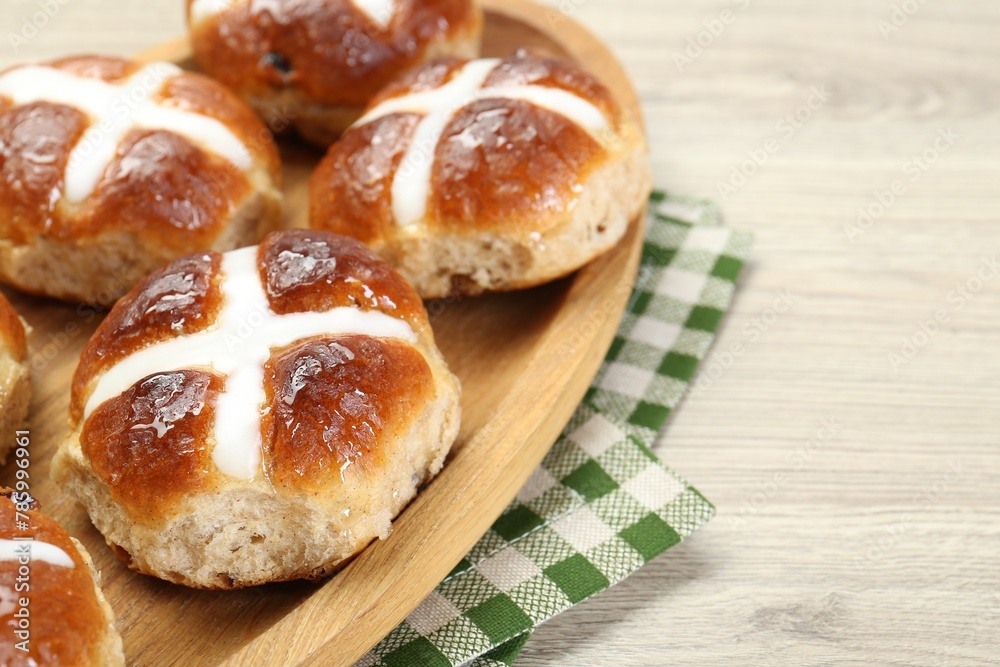 Tasty hot cross buns on wooden table, closeup. Space for text