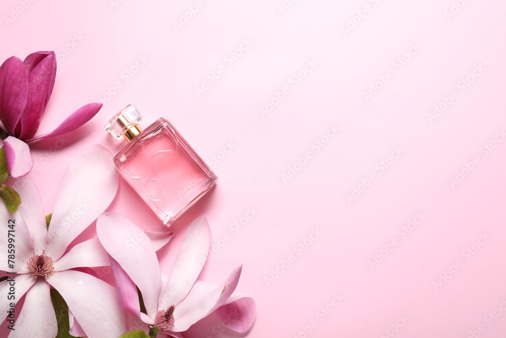 Beautiful magnolia flowers and bottle of perfume on pink background, flat lay. Space for text Beautiful magnolia flowers and bottle of perfume on pink background, flat lay. Space for text