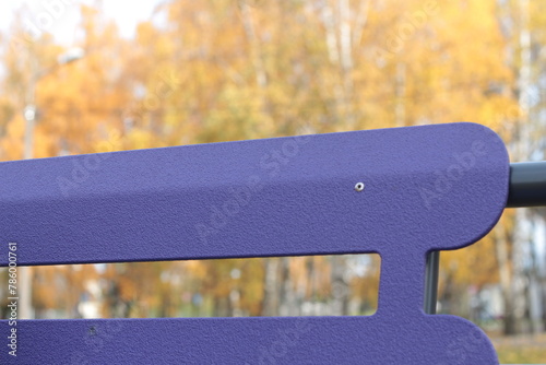  Lilac wooden bench in the autumn park 