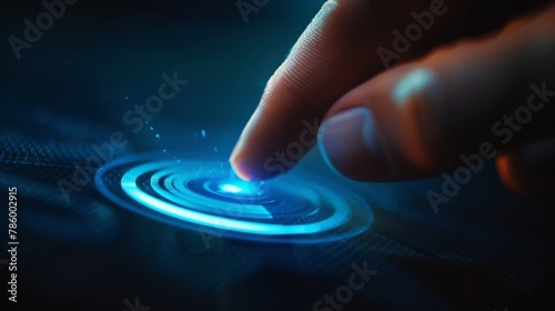 A finger pressing a glowing blue button. photo